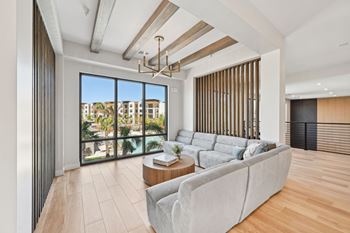 A modern living room with a grey sofa and a view of the city. at The Concord Luxury Apartments, Sarasota, FL